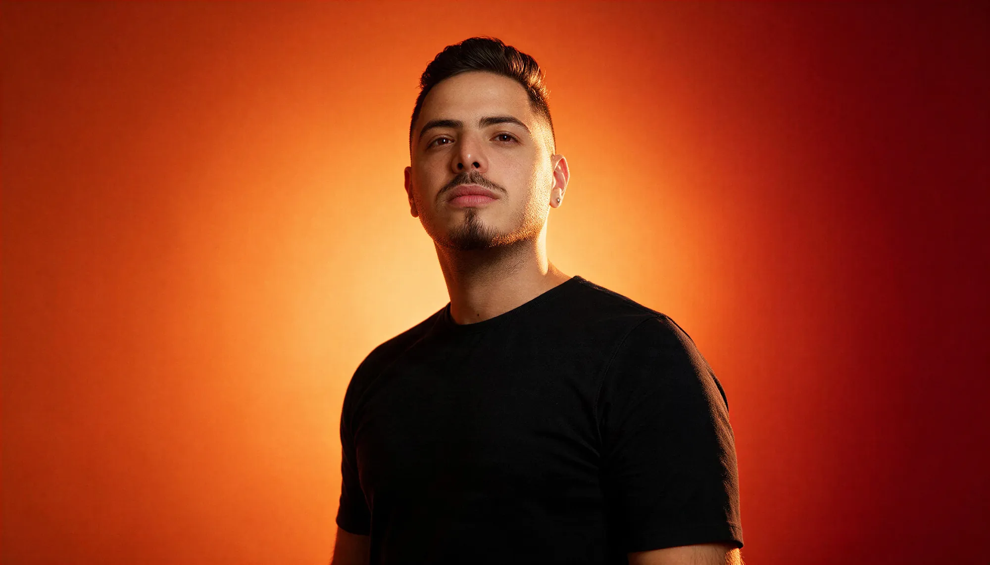 Alexandre Massocato em retrato com fundo laranja